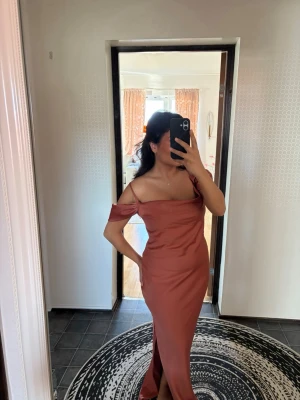 Balklänning med slits - En helt oanvänd otrolig fin satin balklänning. Har en fin slit vid ena benet, diskret dragkedja vid sidan (se bild), man kan dessutom ta upp ärmarna om man så önskar. Klänningen är inte genomskinlig alls. Skriv om ni har fler funderingar 🩷 Passar en M också