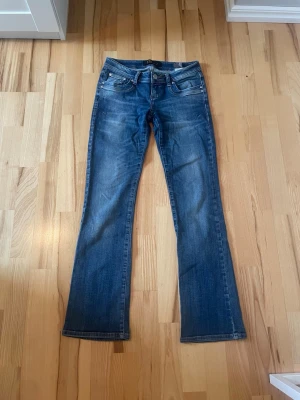 Blå lågmidjade bootcut jeans från LTB - Snygga blå lågmidjade bootcut jeans med klassisk femficksmodell från LTB i modellen Valerie. Storleken är W27 och längd 32. Innerbenslängden: 78 cm, Midjemått: 36 cm platt från sida till sida. Skriv om ni har några frågor💕