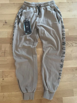 Snygga Beiga Mjukisbyxor Från WOXO I Stl S 👌 - Beiga träningsbyxor från WOXO 🤍✨ Mycket bra skick och perfekta för både träning och mysiga dagar. Det stretchiga materialet ger en superbekväm passform och följer kroppen snyggt 😍  Stilrena, sköna och lätta att matcha 🧘‍♀️  📏 Storlek: S Innerbenslängd: 66 cm Ytterbenslängd: 99 cm Midjemått: 66 cm omkrets Bensbredd: 46 cm omkrets  💰 Pris: 79 kr Ett riktigt kap 💫