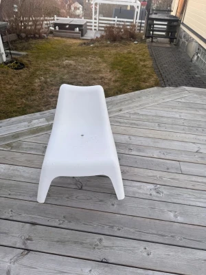 Vit loungestol i plast för barn - IKEA - BARN-stol. Säljer en vit loungestol i plast med modern, låg design och mjuka former. Perfekt för altanen eller trädgården. Stolen har ett hål i sitsen för dränering och är enkel att flytta runt. Passar bra för chill utomhushäng.