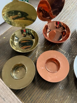 Metallaskar i guld och koppar - Säljer fyra runda metallaskar i spegelblank finish, två i guld och två i koppar. Askarna har lock och en liten fördjupning i mitten av locket. Perfekta för småsaker eller dekoration. Märkning syns undertill på en av askarna.