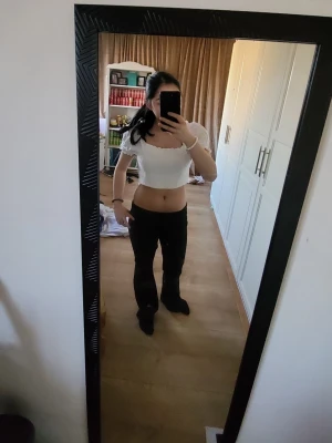 Vit croppad blus med puffärmar - Säljer en söt vit croppad blus med puffiga korta ärmar och smockad kropp. Toppen har en fyrkantig ringning och volangdetaljer vid ärmslut och nederkant. Perfekt för dig som gillar trendiga och feminina plagg.