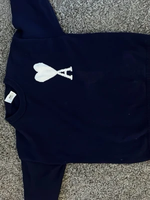 Mörkblå stickad tröja från Ami - Snygg mörkblå stickad tröja från Ami den e strl M och i fint skick, fraktar samma dag som du köper.