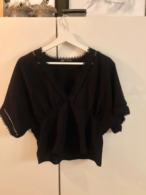 Svart blus med spets från Zara - Säljer eftertraktade blusen från Zara med v-ringning och fina spetsdetaljer längs halsringning och ärmslut. Så snygg och knappt använd därav super fint skick🖤