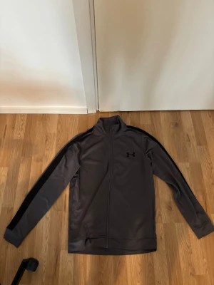 Under armour tracksuit  - Säljer en grå under armour tracksuit, pris kan diskuteras och kan sänka priset vid snabb affär, fraktar samma dag eller dagen efter vid sent köp
