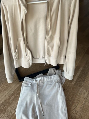 Beige mjukisdress från Gina Tricot - Superskön beige mjukisdress från Gina Tricot med zip-hoodie och matchande byxor. Hoodien har dragkedja, fickor och snören i huvan. Byxorna har resår i midjan och dragsko för bästa passform. Perfekt för chill dagar hemma eller när du vill vara extra bekväm. Tröjan i s och byxor i storlek xs, pris går att diskuteras🤗