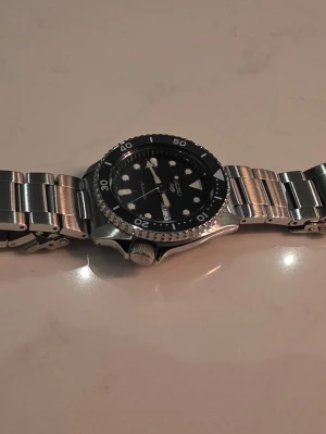 Seiko 5 Sports SRPD55K1 - Seiko 5 Sports SRPD55K1 Automatic 42.5mm – Fullset – Säljer min Seiko 5 Sports SRPD55K1 i mycket fint skick. Klockan är sparsamt använd då jag har flera andra klockor i min samling. Den fungerar perfekt och har mest legat i klocklåda. Specifikationer Modell: Seiko 5 Sports SRPD55K1 Storlek: 42.5 mm Automatiskt urverk (Seiko 4R36) Dag & datum Vattentät 100 m Hardlex glas Original stållänk Ingår Original box Certifikat / garantikort Manual Extra länkar.