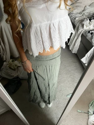 Ljusgrön långkjol med resårmidja - Säljer en ljusgrön långkjol med bred resår i midjan och avslappnad passform. Kjolen har ett skirt, skrynkligt tyg som ger en bohemisk känsla och passar perfekt till sommaren. Enkel att matcha med olika toppar för en chill look. Nypris 600