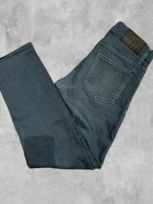 Mörkblå raka jeans - Snygga mörkblå jeans med rak passform och klassisk femficksdesign. Jeansen har en diskret läderpatch bak i midjan och är tillverkade i ett slitstarkt denimtyg. Perfekta för en avslappnad och trendig look.