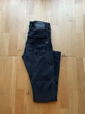 Replay Anbass W30 L32 - Säljer ett par feta Replay Anbass i svart färg. Byxorna är i fint skick, kom PM för fler bilder eller andra funderingar!