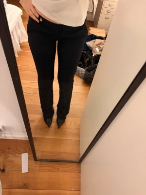 Svarta raka kostymbyxor - Snygga svarta kostymbyxor med rak passform och normal midja. Byxorna har en klassisk look och är perfekta för en stilren outfit. Materialet ser ut att vara en mjuk och följsam blandning, vilket ger en bekväm känsla. Passar till både skjorta och t-shirt. Super populära 