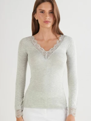 Ljusgrå långärmad topp med spets - Supersnygg ljusgrå långärmad topp med v-ringning och spetsdetaljer vid halsringning och ärmslut. Figurnära passform som framhäver siluetten. Perfekt att styla med både jeans och kjol för en trendig look.