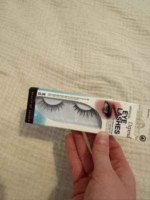 Depend Elin lösögonfransar svart - Säljer ett par svarta lösögonfransar från Depend i modellen Elin. Fransarna har en naturlig form med längre strån mot ytterkanten för en markerad look. Perfekta för att framhäva ögonen och kommer i en smidig förpackning. Oöppnad paket och aldrig kommit till användning