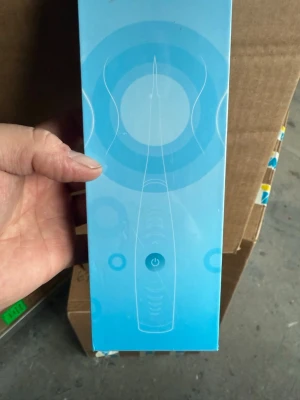 Elektrisk sonisk tandstensborttagare - Säljer en elektrisk tandrengörare i blå förpackning. Produkten har en smal, ergonomisk form med en tydlig på/av-knapp på framsidan. Perfekt för dig som vill ha extra noggrann tandvård hemma.