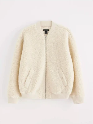 Piléjacka från Lindex - Mysig slutsåld teddyjacka från Lindex med dragkedja framtill och två snedställda fickor. Jackan har ribbade muddar vid ärmslut, hals och nederkant. Perfekt för att hålla sig varm och snygg under kyliga dagar.