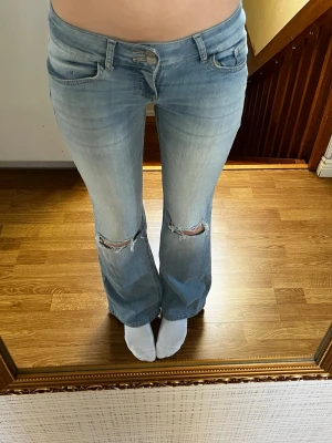 Ljusblå Lågmidjade jeans - Ljusblå lowwaist bootcut jeans från Nelly i storlek 36, de är använda. Modellen heter Low Waist Bootcut Flap Pocket Jeans