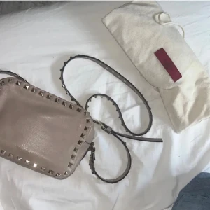 Beige axelväska med nitar Valentino - Säljer min beige/rosa valentinoväska som är superfin! Den har slitage och inte kvitto därav priset men finns dustbag. ❤️ kan komma med lägre pris vid snabb försäljning! Den är lite smutsig inuti men inte något som märks. Kan skicka fler bilder på den om ni kommer privat men vill ej ha några byten! ❤️ är man intresserad få man ha i åtanke att det finns vissa slitage men att den fortfarande är jättefin på och skicket ser fortfarande bra ut! ❤️