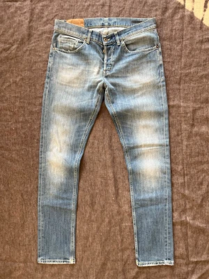 Ljusblå Dondup George jeans, storlek 34 - Ljusblå tvättade Dondup George jeans med diskreta slitningar  Midja: 42 cm Längd: 104 cm Lårbredd: 27 cm Benöppning: 16 cm  Hör av er vid frågor! 