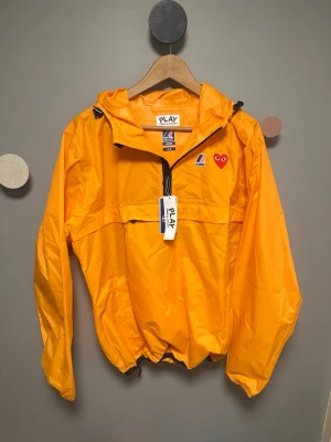 Comme des Garçons x K-Way  - Snygg vindjacka från K-Way i samarbete med CDG Play. Jackan har den ikoniska hjärt-loggan på bröstet. Materialet är lätt och vattenavvisande, perfekt för att hålla sig torr och stilren. PLAY-taggen sitter kvar. Säljer den helt ny oanvänd pga att jag fick den i present och har ingen användning för den! Den sitter som en M i storlek 