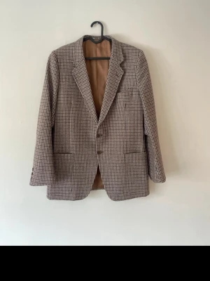 Kavaj från NK - Säljer en otroligt fin hundtandsmönstrad kavaj från NK Är i mycket bra skick, och skräddarsydd till perfektion sedan något år tillbaka.  Storlek: 50  Mått: Axelbredd: 48cm Midjemått: 46cm Längd: 76cm Armlängd: 63cm