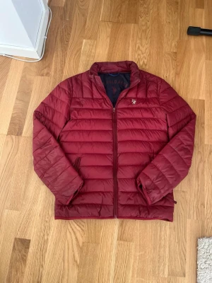 Vårjacka! - Snygg vinröd vårjacka från U.S. Polo Assn. med broderad logga. Säljer för att den börjar bli för liten, inga skavanker förutom lite grå färg på vänstra ärmen (se bild 5) Jag är 187cm lång och den är lite för kort för mig. Skickar alltid inom 24 timmar!