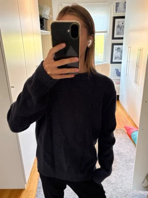 Mörkblå stickad tröja  - Mysig mörkblå stickad tröja med rund halsringning och ribbade muddar vid ärmslut och nederkant. 