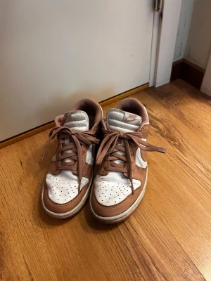 Nike vit/rosa sneakers - Nike sneakers i vitt och rosa. Väldigt stilrena och passar till de mästa. Även en väldigt skön sko säljs pågrund av att dom är försmå.