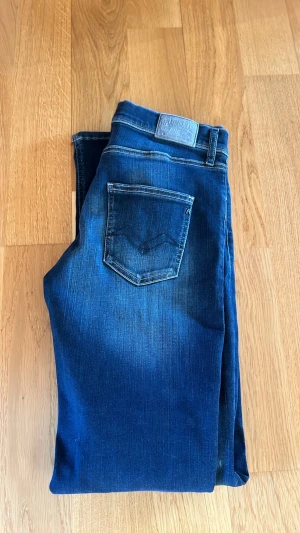 Mörkblå jeans från Replay - Snygga mörkblå jeans från Replay med klassisk femficksdesign och tydliga kontrastsömmar. Jeansen har en patch med Replay-logga bak i midjan och är tillverkade i ett mjukt denimtyg med lätt tvättad look.