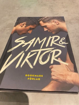 Samir & Viktor bok Bookmark Förlag - En snygg och modern bok med titeln 'Samir & Viktor' från Bookmark Förlag. Omslaget har ett porträttfoto i färg med stora, handskrivna bokstäver. Inlagan innehåller bilder och personliga fakta om huvudpersonerna. Perfekt för dig som gillar biografier och popkultur.
