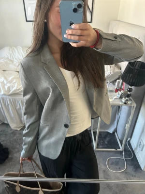 Grå  kavaj - Snygg grå kavaj med diskret rutmönster och klassisk krage. 