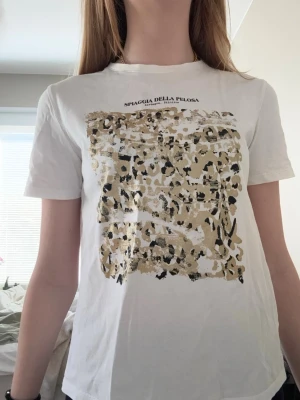 Vit t-shirt med leopardmönster Zara - Vit t-shirt från Zara med beige och svart leopardmönster framtill, perfekt till sommaren!🌺