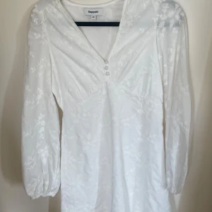 Vit blommig klänning  - Superfin  vit klänning från Kappahl med blommönster, v-ringning och knappar framtill. Perfekt nu till sommaren. Använd en gång så i jätte bra skick. I storlek xs men passar mig som är normalt storlek S, Skriv gärna om frågor💕💕