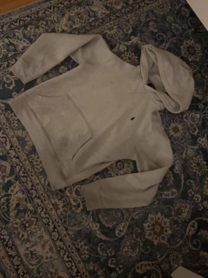 Grå hoodie från Polo Ralph Lauren - Snygg grå hoodie från Polo Ralph Lauren med klassisk huva och stor magficka. Diskret logga på bröstet och mjukt material som känns skönt mot huden. Perfekt för dig som gillar en clean och enkel stil.