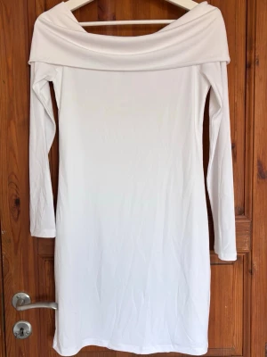 Vit offshoulder långärmad klänning - Säljer en stilren vit klänning från Bik Bok med offshoulder-design och långa ärmar. Klänningen har en rak passform och är tillverkad i ett mjukt, stretchigt material som ger en bekväm känsla. Perfekt för dig som gillar minimalistisk och trendig stil. Aldrig använd, lappen är kvar 💘