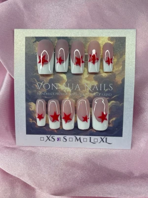 Famous (S);Medium Square - Snygga handgjorda press-on naglar i en cool fransk design med nude bas, vit tipp och en röd stjärna på varje nagel. Naglarna har en medium längd , squareform stil och är handgjorda i S: 15 mm, 11,5 mm, 12 mm, 11 mm, 9 mm. Perfekt för dig som vill sticka ut med en unik look.