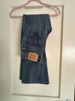Levi's bootcut jeans - Ett par vintage Levi’s bootcut jeans som är midwaisted. Har storlek W27 L32. Det finns en fläck fram på höger ben. Hör av dig om du har några frågor💕(Kan tyvärr inte visa en bild med dem på eftersom jag inte kan knäppa knappen)