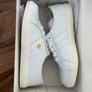Vita sneakers från Lauren Ralph Lauren - Stilrena vita sneakers från Lauren Ralph Lauren i storlek 38! Superbra skick, endast testade då de var förstora för mig. Nypris 1200kr! Priset går att diskutera💓