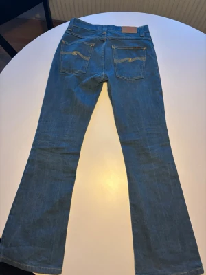 Nudie jeans flare Glenn  - Säljer ett par nudie jeans i modellen flare Glenn i 30/32 femficksdesign och snygga detaljer på bakfickorna. Jeansen har normal midja och är tillverkade i slitstarkt denim-material. Perfekt för dig som gillar en tidlös och avslappnad look.