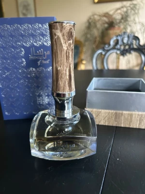 Mirsaal of Trust Afnan - Exklusiv parfym från Mamlakat Al Oud med elegant glasflaska och unik kork i trälook. Topnoter: ambroxan, vetiver.       Mellannoter: hallon, saffran               Basnoter: cashmere, amber, nejlika