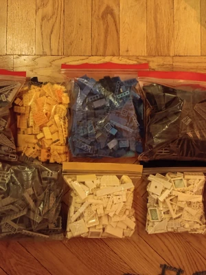 Stort paket med LEGO-bitar i blandade färger - Säljer flera påsar med LEGO-bitar i olika färger som blått, gult, brunt, vitt och grått. Perfekt för dig som vill bygga egna kreationer eller fylla på din samling. Bitarna är sorterade efter färg i zip-påsar och det finns även en påse med blandade delar.