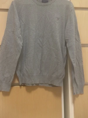 Grå tröja från GANT - Har en fläck på framsidan annars i mycket bra skick fast den har blivit använd!