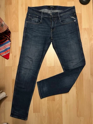 Mörkblåa replay anbass jeans  - De är som helt nya använd väldigt sparsamt. Inga hål eller defekter. Snygga replay anbass jeans, perfekt passform då jeansen ej är slim eller regular precis emellan. Storlek 30/32. Fraktar inom 24 timmar hör gärna av er.