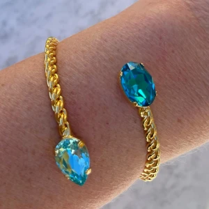 Armband Bangle Aquamarine  - Armband, Bangle, i guldpläterad mässing med kristaller. Kristaller Pear 14mm och Oval 14mm, Färg Aquamarine och Dark Aquamarine. Ställbar storlek.  Jag skickar endast spårbart, samfraktar. Fast pris. Besök gärna mina övriga annonser.  Till mina smycken använder jag kristaller från Preciosa, Aurora och Swarowski.