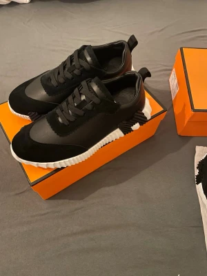 Svarta  sneakers med vit sula - Snygga svarta sneakers från lager 157 med vit räfflad sula och svarta detaljer i mocka och läder. Skorna har en modern design med svarta skosnören och diskret logga på hälen. Perfekta för dig som vill ha en exklusiv och stilren look.