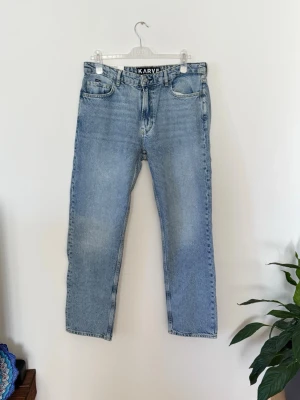 Ljusblå raka jeans från Karve Helt ny och oanvänd med prislapp kvar. - Säljer ett par ljusblå raka jeans från Karve med klassisk femficksmodell och hög midja. Jeansen har en avslappnad passform och är tillverkade i 100% bomull för en autentisk denimkänsla. Perfekta för en casual och trendig look.Helt ny och oanvänd med prislapp kvar.