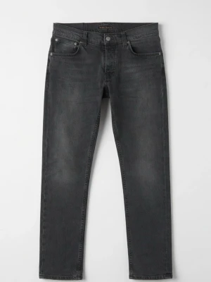 Nudie Jeans Grim Tim - Säljer ett par gråa slim fit jeans i modellen grim tim från Nudie Jeans. Jeansen har klassisk femficksdesign, knappgylf och subtila slitningar för en avslappnad look. Materialet är mjukt denim med lite stretch för extra komfort.