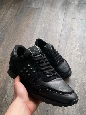 Valentino Rockrunners skor - Säljer ett par riktigt snygga Valentino Rockrunners i färgen svart. Dessa är väldigt välkända och snygga. Skicket är 7/10 då lite nitar är av, men de är snyggt. Storleken är 43. Priset kommer ligga på 1099kr men kan sänkas.