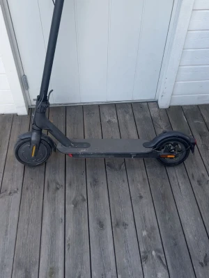 Svart elscooter Xiaomi Mi Electric - Säljer en svart elscooter från Xiaomi, modell Mi Electric Scooter. Scootern har robust ram i metall, stora hjul och handtag med gummi för bra grepp. Batteriet är integrerat i plattan och det finns reflexer på hjulen för extra synlighet. Den har 3 olika hastighetslägen och kör 20km med sport. Det finns lite repor men inget som hindrar din körning. 