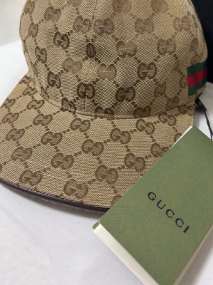 Gucci keps - Beige Gucci Keps, helt ny med box. Riktigt fin och passar de flesta outfitsen och används som ett vardagligt plagg! Pris kan diskuteras