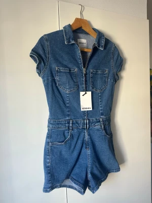 Jeansjumpsuit från Bershka - Aldrig använd, jag är 1.68 och den sitter perfekt!! Storlek M men skulle nästa mer säga att den sitter som en S. Tyvärr får jag ej användning för den. Köpte för 325+frakt. 